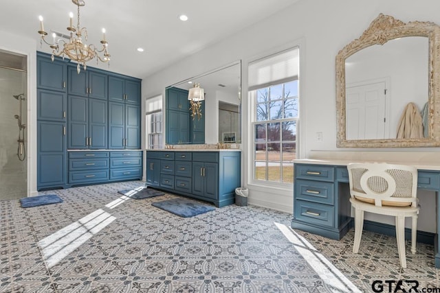 bathroom featuring vanity, a notable chandelier, and a shower with door