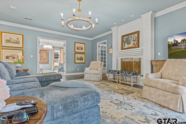 living room featuring a fireplace, ornamental molding, and an inviting chandelier