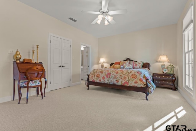 bedroom featuring connected bathroom, ceiling fan, and light colored carpet