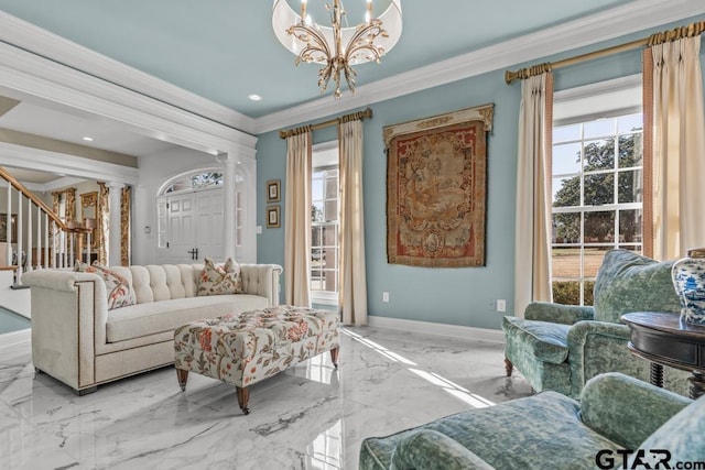 living room featuring decorative columns, crown molding, and a chandelier