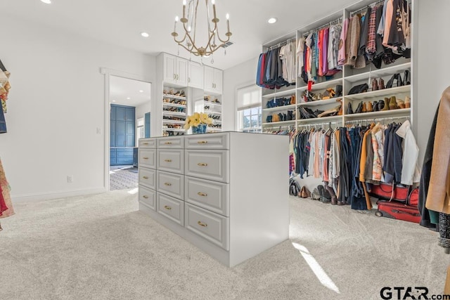 walk in closet with a notable chandelier and light colored carpet