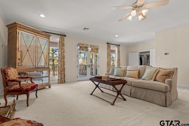 living room with light carpet, a wealth of natural light, and ornamental molding