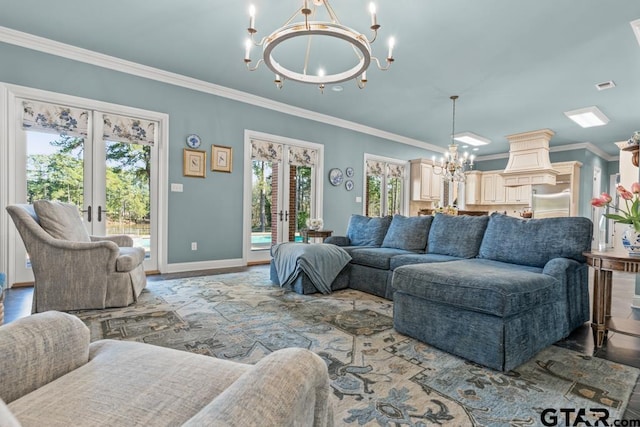 living room featuring french doors, crown molding, a chandelier, and a healthy amount of sunlight