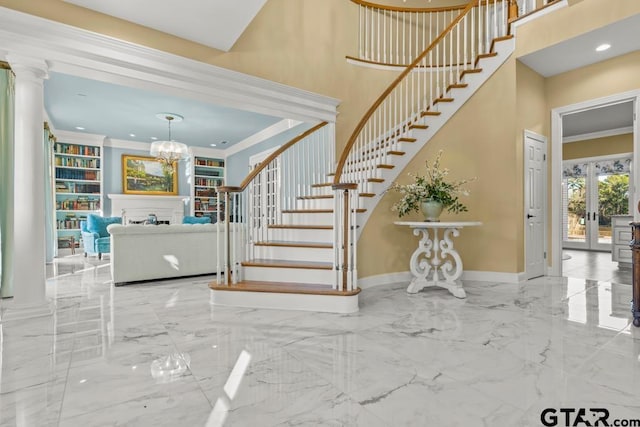 foyer entrance featuring crown molding, decorative columns, french doors, and a towering ceiling