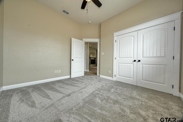 unfurnished bedroom featuring ceiling fan, a closet, and carpet