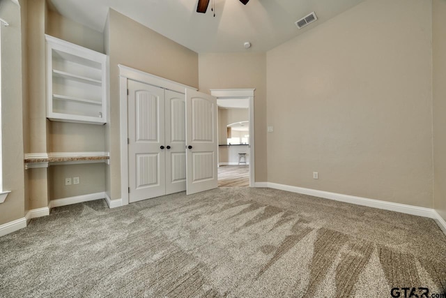 unfurnished bedroom featuring ceiling fan, a closet, and light carpet