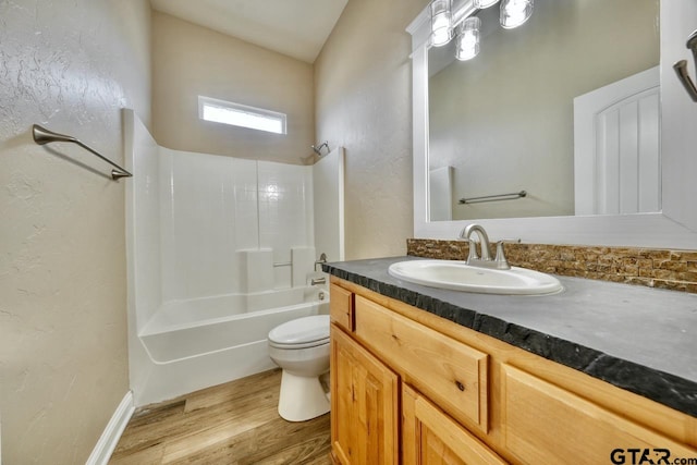 full bathroom featuring hardwood / wood-style floors, vanity,  shower combination, and toilet