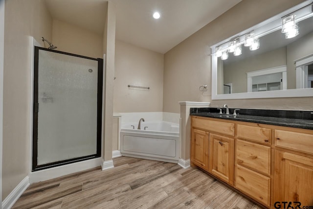 bathroom featuring hardwood / wood-style floors, vanity, and independent shower and bath