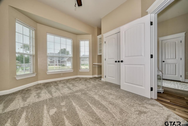 unfurnished bedroom with ceiling fan, carpet floors, and a closet