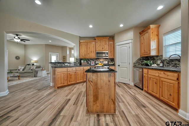 kitchen featuring a center island, sink, ceiling fan, light hardwood / wood-style floors, and stainless steel appliances