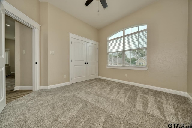 unfurnished bedroom featuring carpet flooring, a closet, and ceiling fan