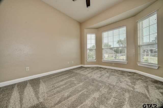 empty room with ceiling fan, carpet floors, and vaulted ceiling