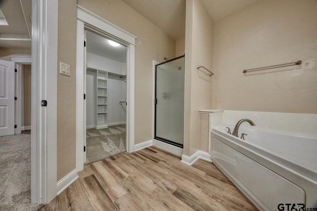 bathroom with hardwood / wood-style floors and plus walk in shower