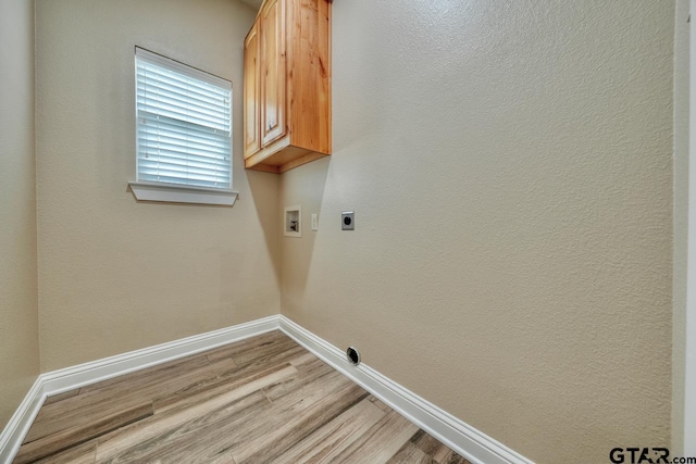 laundry area with electric dryer hookup, cabinets, washer hookup, and light wood-type flooring