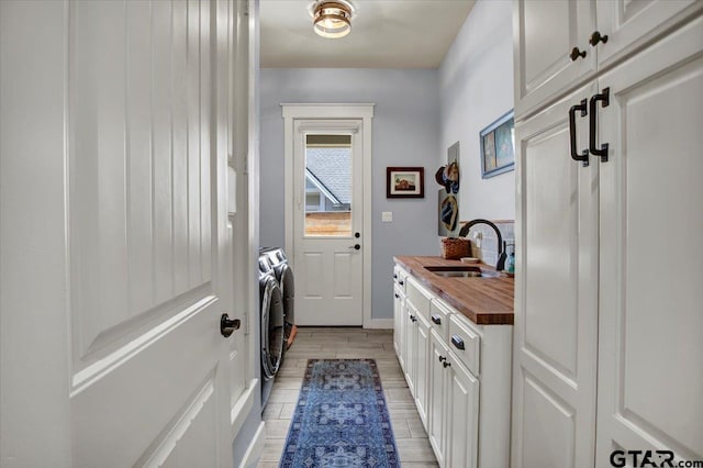 14621 Twin Pine Ln, Lindale, TX 75771 - laundry room featuring washing machine and clothes dryer, cabinet space, and light wood-style floors