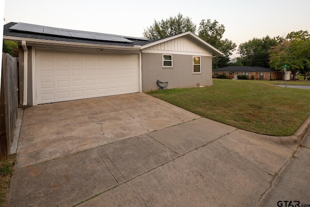 1400 Santa Rosa, Tyler, TX 75701 - view of property exterior with concrete driveway, roof mounted solar panels, a yard, brick siding, and a garage