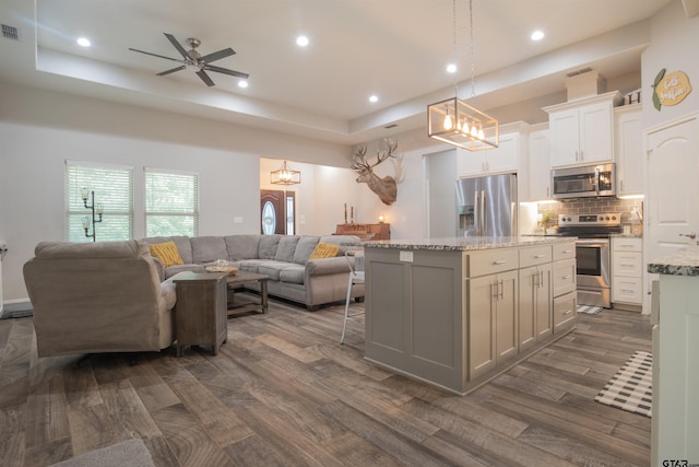 17294 Hidden Valley Ln, Flint, TX 75762 - kitchen with appliances with stainless steel finishes, open floor plan, a center island, light stone countertops, and backsplash