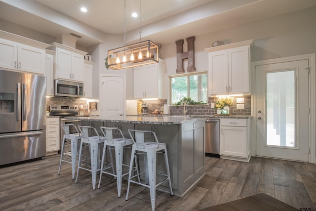17294 Hidden Valley Ln, Flint, TX 75762 - kitchen with stainless steel appliances, a kitchen island, white cabinets, a breakfast bar, and recessed lighting