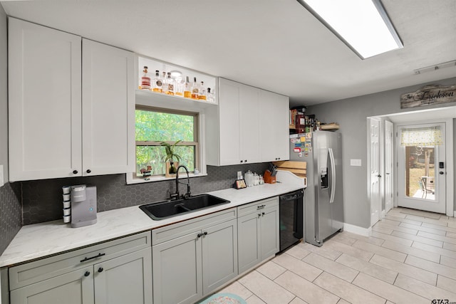 kitchen with tasteful backsplash, black dishwasher, stainless steel refrigerator with ice dispenser, sink, and white cabinets