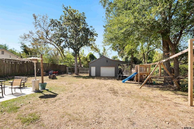 view of yard with a patio, a playground, a garage, and an outdoor structure