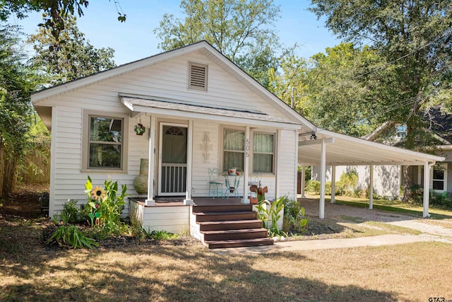 view of front facade featuring a porch, a front yard, and a carport