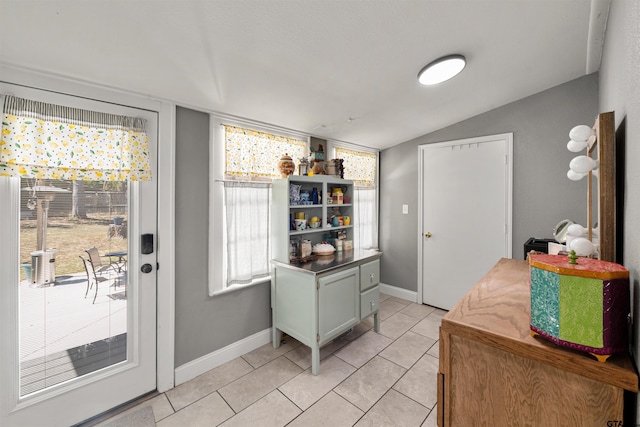 interior space with lofted ceiling and light tile patterned floors