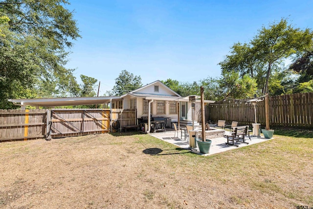 back of house with an outdoor fire pit, a yard, and a patio area