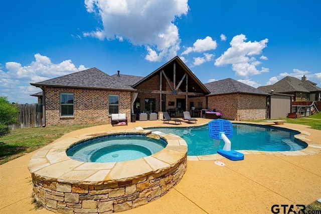 view of pool featuring a patio area, a pool with connected hot tub, and fence