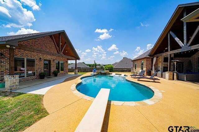 view of pool with a diving board, a patio area, and a fenced backyard