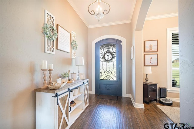 entrance foyer with dark wood-style floors, arched walkways, ornamental molding, a chandelier, and baseboards