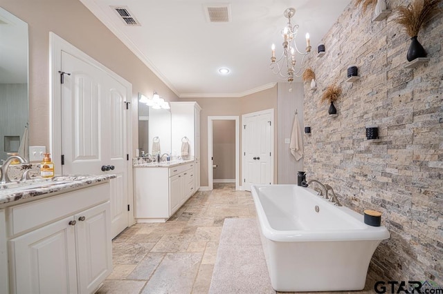 full bath featuring visible vents, stone tile flooring, crown molding, a freestanding bath, and a sink