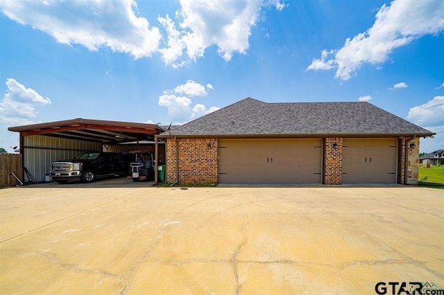 ranch-style home with a garage, a shingled roof, concrete driveway, a carport, and brick siding