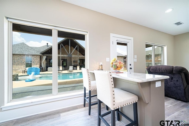 dining room featuring light wood finished floors, baseboards, visible vents, and recessed lighting