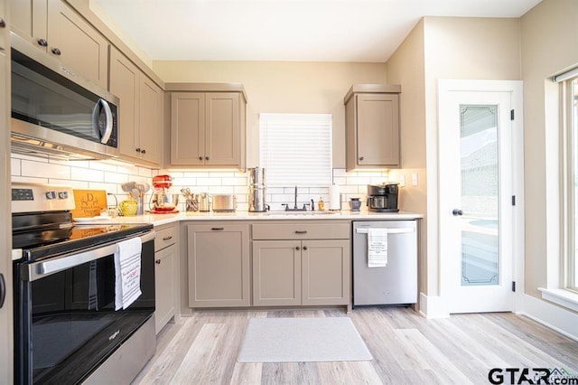 kitchen with stainless steel appliances, gray cabinets, and a sink