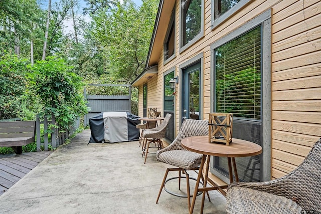 view of patio / terrace featuring a deck, a grill, and fence