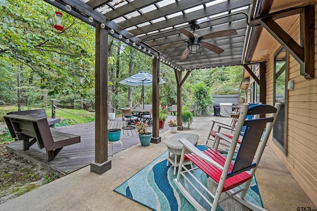 view of patio featuring a deck, a ceiling fan, outdoor dining area, and a pergola