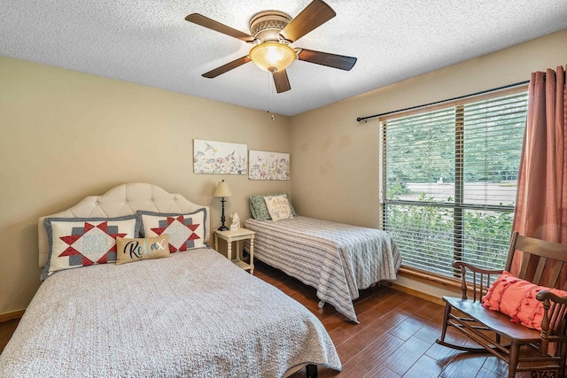 bedroom featuring a textured ceiling, multiple windows, and wood finished floors