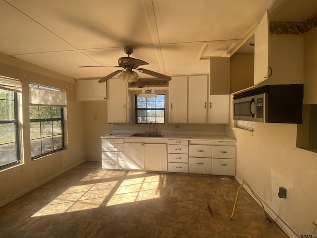 kitchen with white cabinetry, sink, ceiling fan, and plenty of natural light