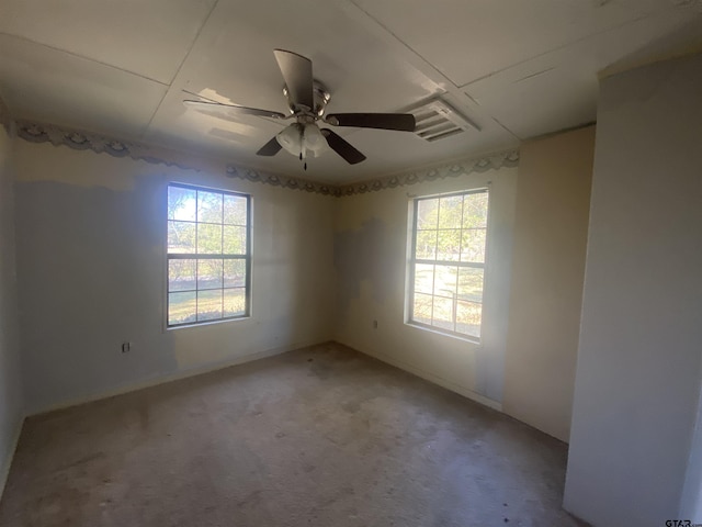 spare room with ceiling fan, plenty of natural light, and carpet floors