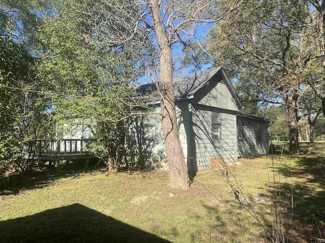 view of property exterior featuring a yard and a wooden deck