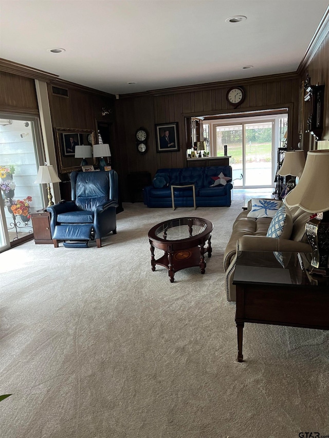 carpeted living room with wooden walls and ornamental molding