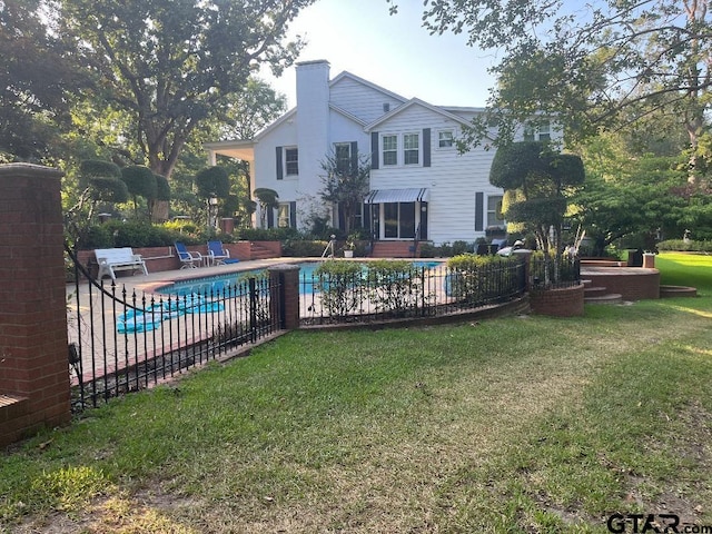 view of pool featuring a lawn