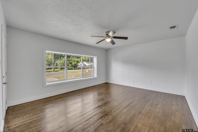 315 E Hubbard St, Lindale, TX 75771 - spare room featuring ceiling fan, dark wood-style flooring, baseboards, and a textured ceiling