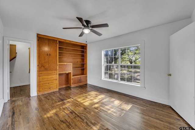 315 E Hubbard St, Lindale, TX 75771 - unfurnished living room featuring ceiling fan, dark wood-type flooring, baseboards, an office area, and built in shelves