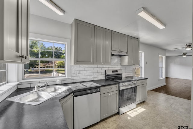 315 E Hubbard St, Lindale, TX 75771 - kitchen with appliances with stainless steel finishes, gray cabinetry, under cabinet range hood, and dark countertops