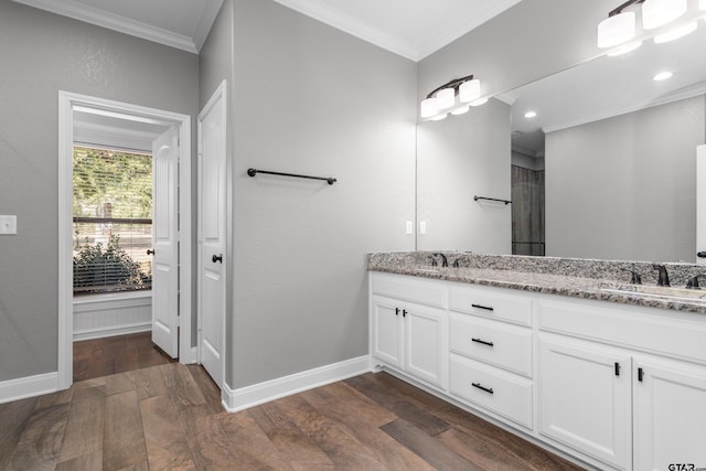 bathroom with hardwood / wood-style flooring, vanity, and crown molding