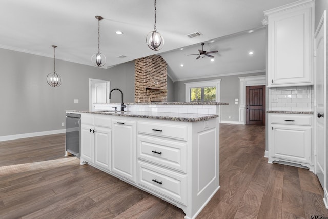 kitchen featuring white cabinetry, pendant lighting, sink, and a kitchen island with sink