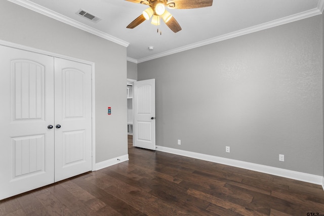 unfurnished bedroom with dark hardwood / wood-style flooring, ceiling fan, crown molding, and a closet