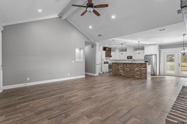 unfurnished living room featuring dark hardwood / wood-style floors, vaulted ceiling with beams, and ceiling fan with notable chandelier