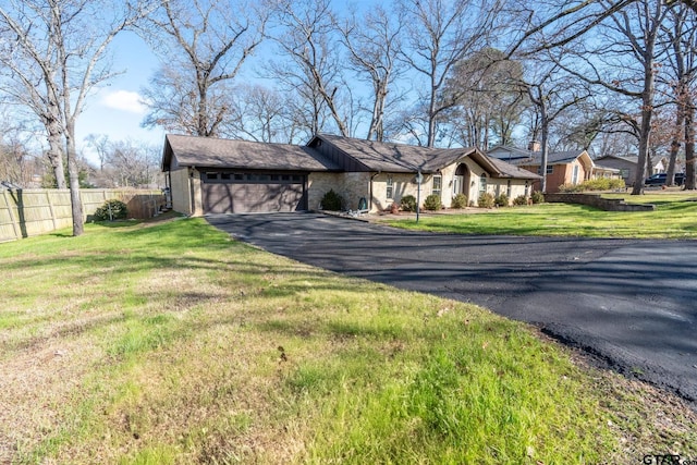 ranch-style house featuring a garage and a front lawn